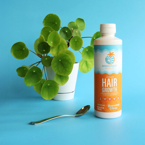 Bottle of vegan hair growth formula with rosemary citrus flavor next to green potted plant and spoon