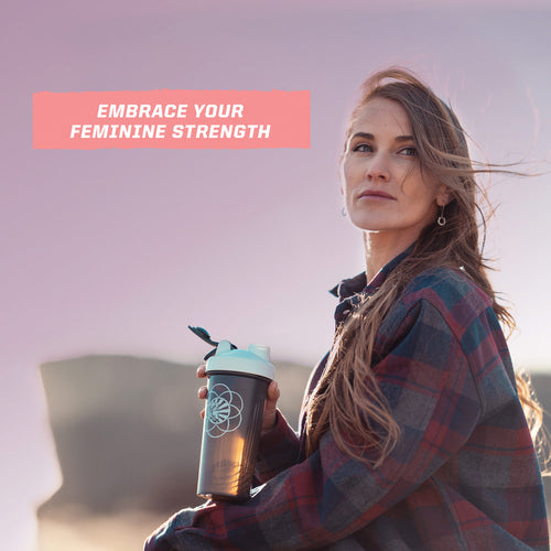 Woman outdoors holding a shaker bottle with text "Embrace your feminine strength" at sunrise or sunset