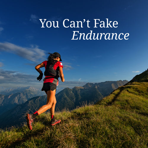 Woman trail running uphill on grassy mountain slope under blue sky with text "You Can't Fake Endurance
